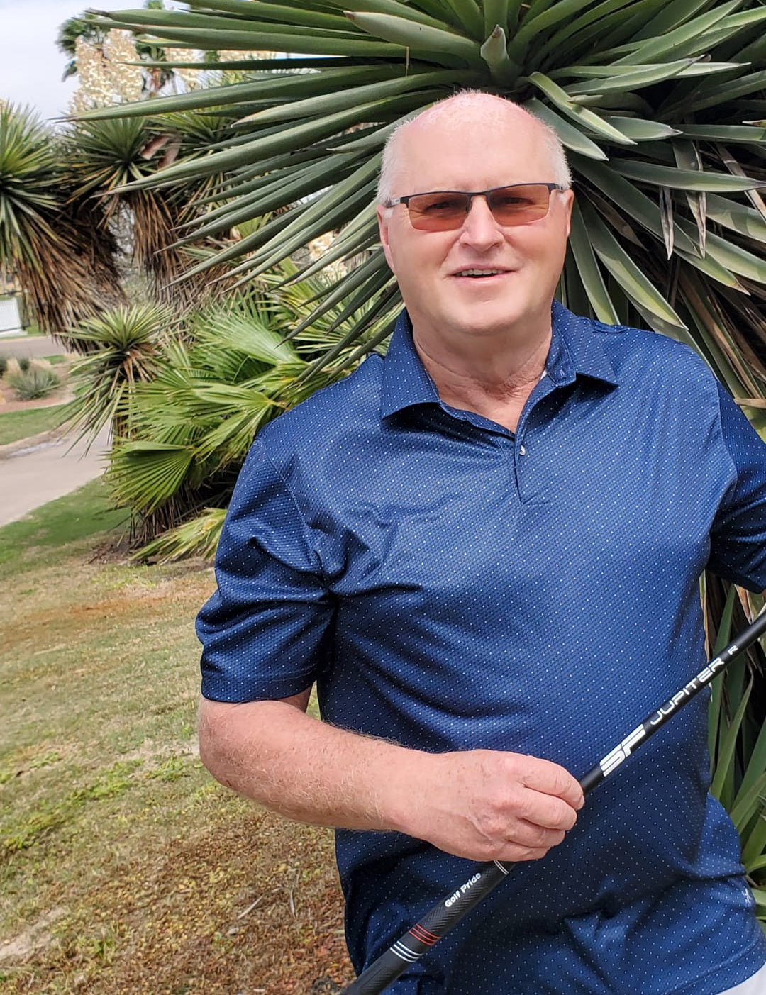 Golfer Wearing Glasses Holding a Steadfast Driver Golf Shaft and Smiling
