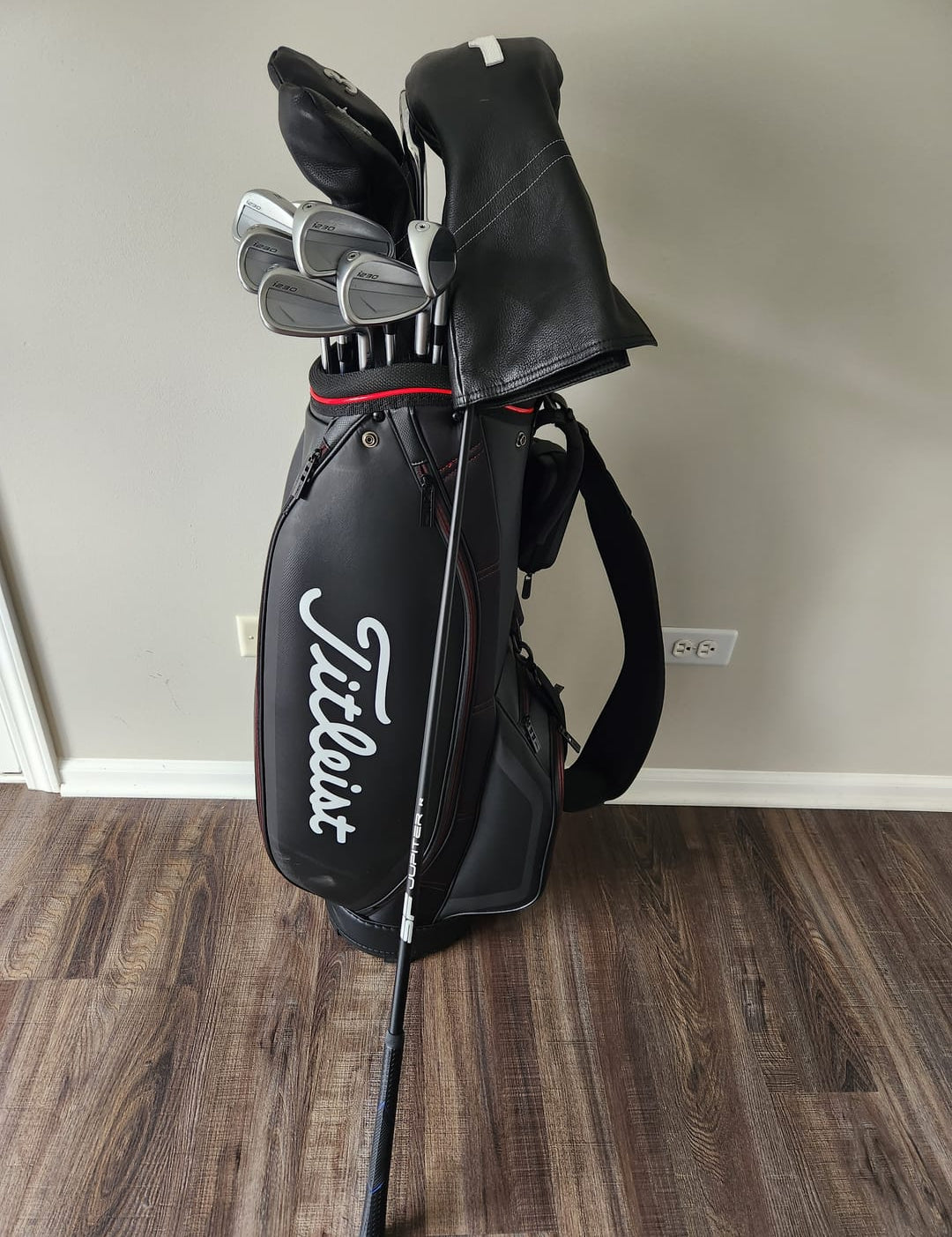 Golf Clubs in a Titleist Bag On a Wood Floor
